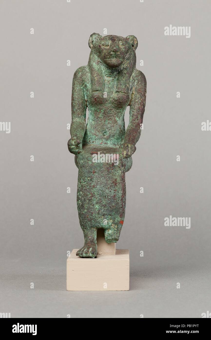 Lion-headed goddess. Dimensions: H. 16.2 cm (6 3/8 in.); W. 5.2 cm (2 1/16 in.); D. 8.9 cm (3 1/2 in.)  H. (with tang): 17 cm (6 11/16 in.). Date: 664-30 B.C..  Lion-headed goddesses in Egypt encompassed numerous deities including Sakhmet, Wadjet, and Bastet, among others. In this guise, the goddesses were fierce protective deities, but ones that could also bring about destruction on behalf of the gods, both through violence and through plague and pestilence. This figure utilizes several iconographic elements common to many lion-headed goddesses including the seated posture, the lion's mane co Stock Photo