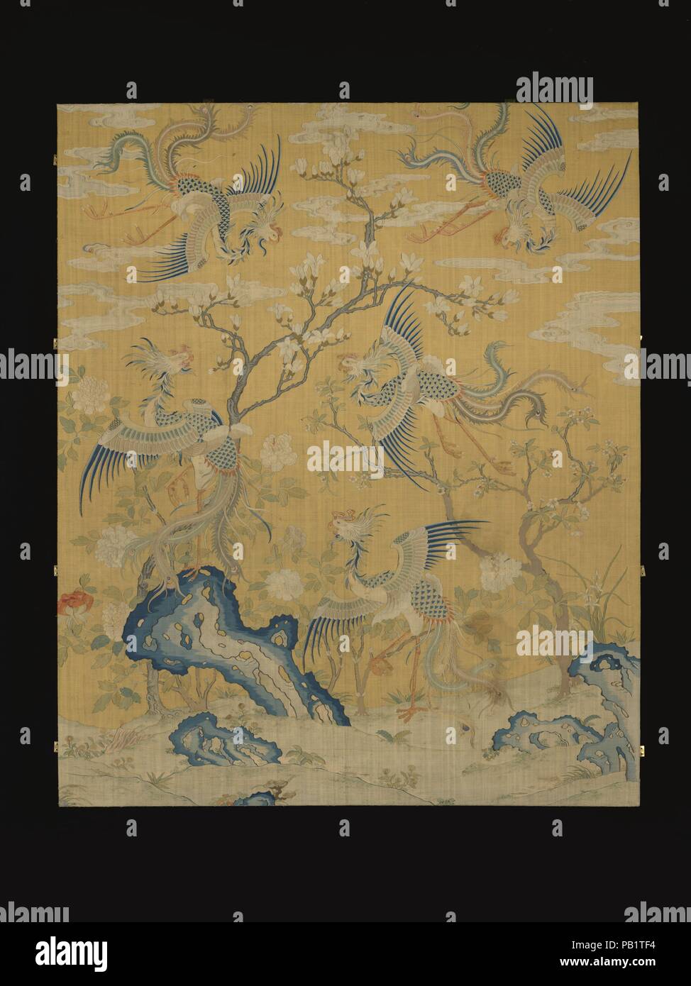 Panel with five phoenixes in a garden. Culture: China. Dimensions: 118 1/2 × 82 in. (301 × 208.3 cm). Date: 18th century.  Large pictorial silk tapestries such as this one were mostly woven in the imperial workshops in Suzhou, a textile center in southeast China. The bright yellow background, a color exclusive to the emperor, further confirms its imperial origins. The five phoenixes probably refer to the five species of this auspicious bird in Chinese myths. This piece is paired with another five-phoenix panel in The Met collection, and the set could represent the five ideal relationships (wul Stock Photo