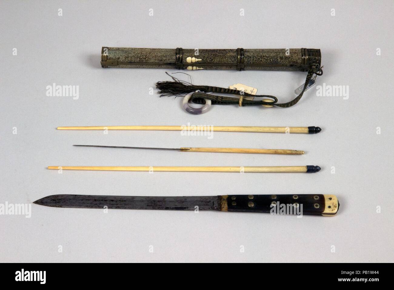 Knife with Sheath, Chopsticks, Pickle Spear and Toothpicks. Culture: Chinese. Dimensions: Knife (a); L. with sheath 13 3/16 in. (33.5 cm); L. without sheath 11 1/4 in. (28.6 cm); W. 3/4 in. (1.9 cm); Wt. 3.1 oz. (87.9 g); sheath (b); Wt. 1.7 oz. (48.2 g); chopsticks (c, d); L. 10 5/16 in. (26.2 cm); W. 1/4 in. (0.6 cm); Wt. 0.4 oz. (11.3 g); pickle spear (e); L. 8 7/8 in. (22.5 cm); W. 3/16 in. (0.5 cm); Wt. 0.2 oz. (5.7 g); earspoon (f); L. 2 13/16 in. (7.1 cm); pick (g); L. 2 13/16 in. (7.1 cm); pick (h); L. 2 15/16 in. (7.5 cm). Date: 18th-19th century. Museum: Metropolitan Museum of Art, N Stock Photo