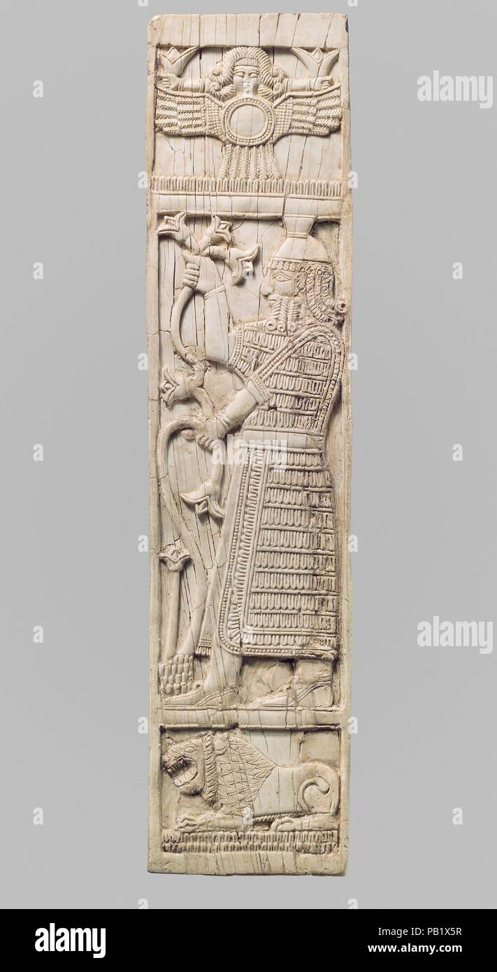 Furniture plaque carved in relief with warrior holding lotuses. Culture: Assyrian. Dimensions: 11.38 x 2.72 x 0.2 in. (28.91 x 6.91 x 0.51 cm). Date: ca. 8th century B.C..  This ivory panel was found in a storage room in Fort Shalmaneser, a royal building at Nimrud that was used to store booty and tribute collected by the Assyrians while on military campaign. Like many other panels from the same storage room, it was part of a chair or couch back or the headboard of a bed. Twenty pieces of furniture were discovered stacked in orderly rows in this room, where they had been stored before the dest Stock Photo