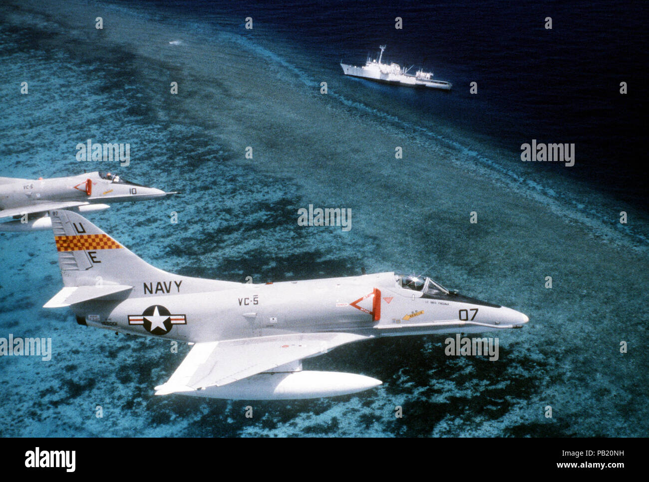 A-4Es of VC-5 in flight over USNS Chauvenet (T-AGS-29) 1981. Two Fleet Composite Squadron 5 (VC-5) A-4E Skyhawk aircraft fly over the surveying ship USNS CHAUVENET (T-AGS-29).  The CHAUVENET has run aground on a reef. Stock Photo