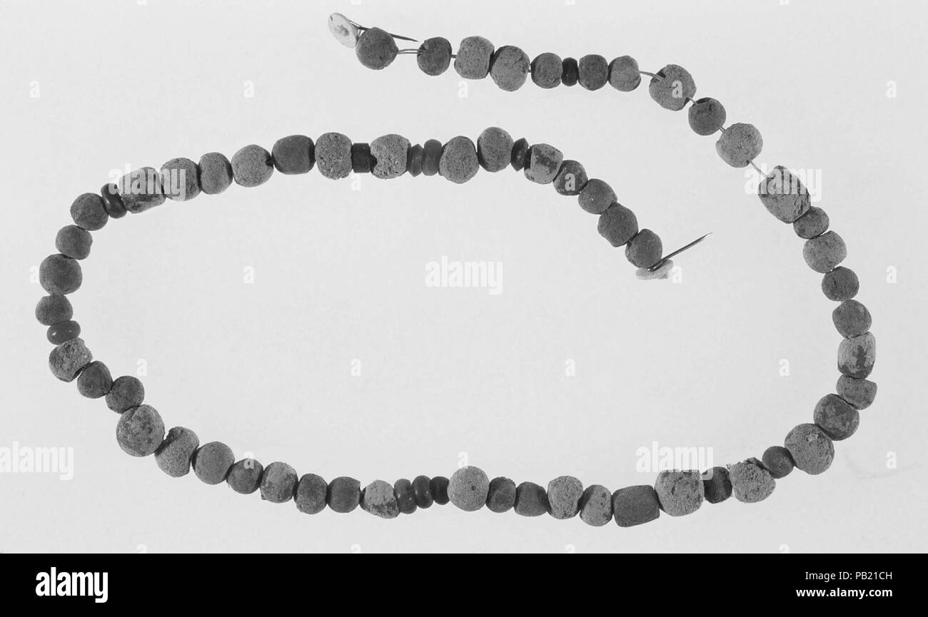 String of beads. Dimensions: L. 44 cm (17 5/16 in.). Date: ca. 3900-3650 B.C..  Even in the earliest graves, everyone was buried wearing their favorite ornaments. Jewelry was simple: necklaces, bracelets, and anklets. Amulets, semi-diadems (forehead ornaments), and belts occasionally occur. Jewelry often provided protection through its shape, material, and color; some pieces conferred status through type or material.   This necklace, of clay and carnelian beads, was found with the burial of a child, along with a number of other luxury and prestige items (see 09.182.1-.8). Clearly the child was Stock Photo