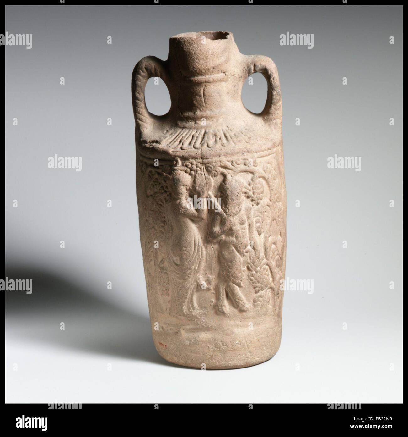 Terracotta amphora (jug). Culture: Roman. Dimensions: H. 10 3/8 in. (26.4 cm). Date: 2nd-3rd century A.D..  This vessel was made at Cnidus, a trading and manufacturing port in Caria (southwestern Turkey), famed for its statue of Aphrodite by the Greek sculptor Praxiteles. The relief decoration shows the god Dionysus on one side and Pan with a dancing nymph on the other. Similar scenes can also be found on much grander examples of Roman art, such as mosaics and marble sarcophagi. Museum: Metropolitan Museum of Art, New York, USA. Stock Photo