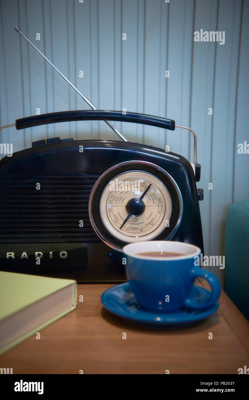 A radio and a cup of tea next to a teal couch Stock Photo - Alamy