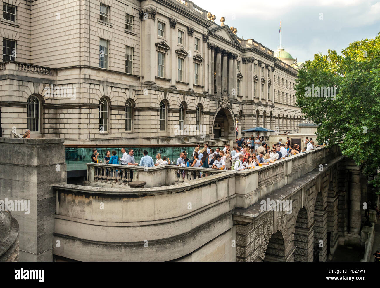 A function with people relaxing and having a drink on the busy terrace outside Somerset House, a Grade 1 Listed Building in London, England, UK. Stock Photo