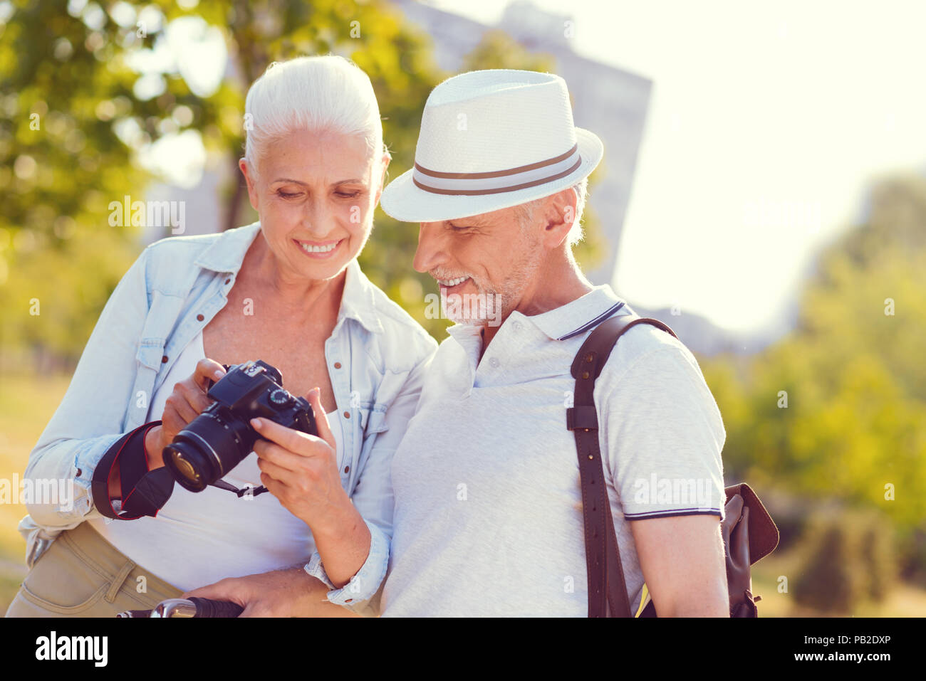 Positive minded couple looking at photo after family photoshoot Stock Photo