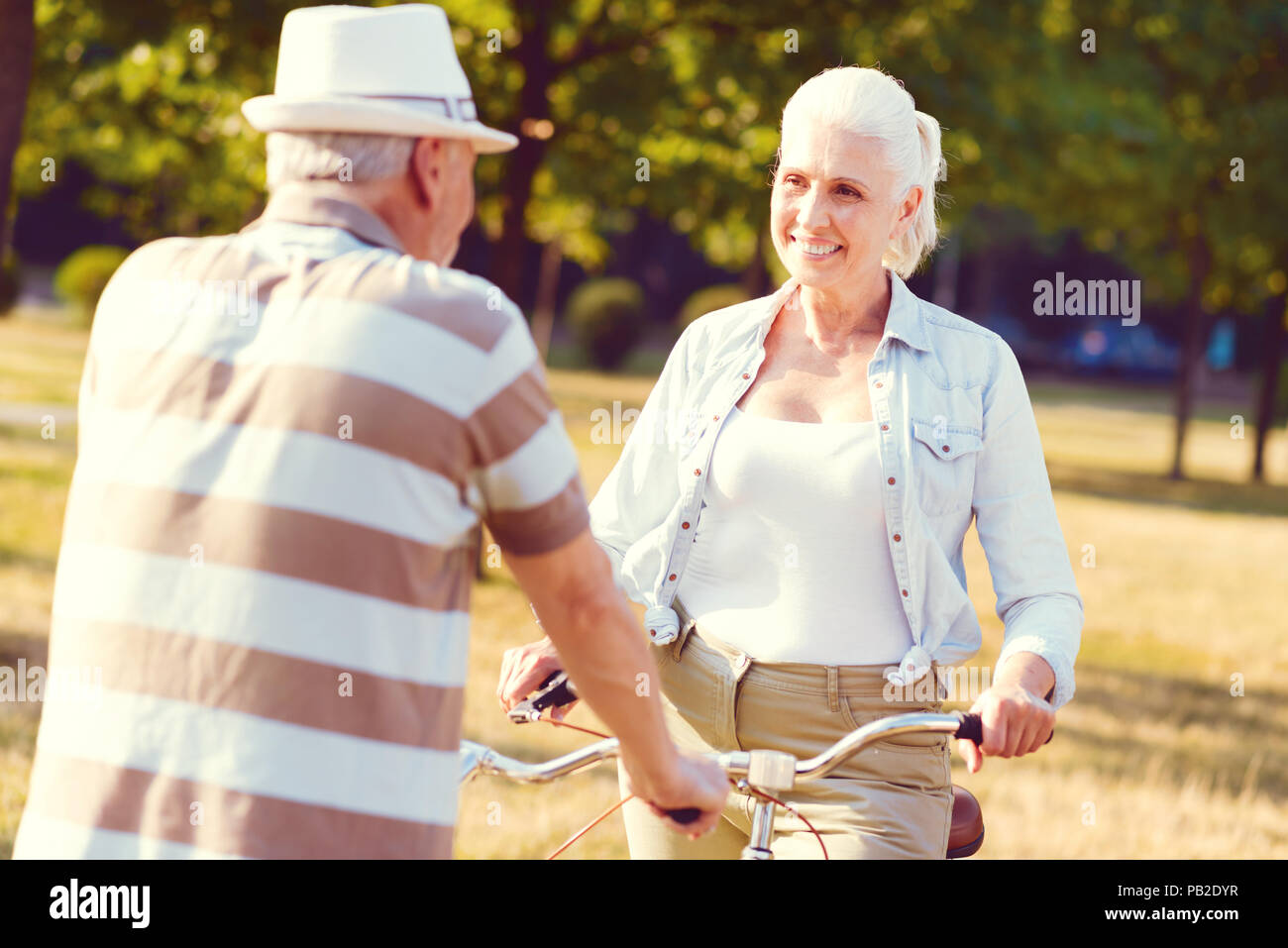 Joyful couple talking while sitting on bicycles Stock Photo