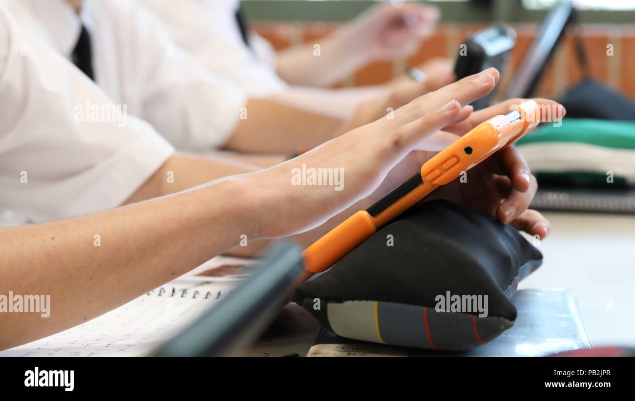 High school students working on using an ipad tablet style electronic computer device. modern pedagogy and teaching learning in education educational Stock Photo