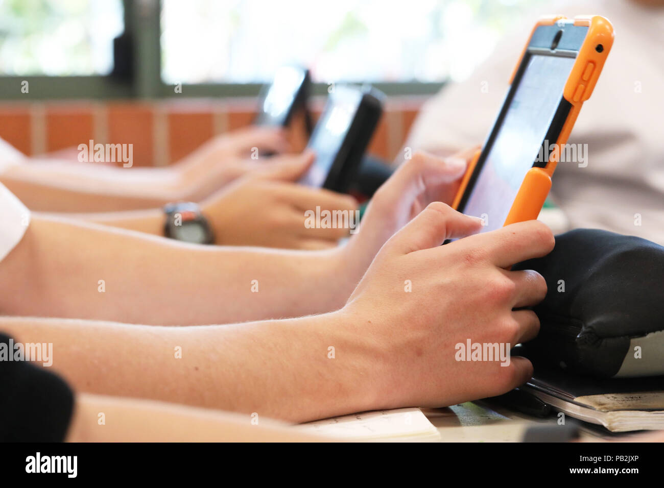 High school students working on using an ipad tablet style electronic