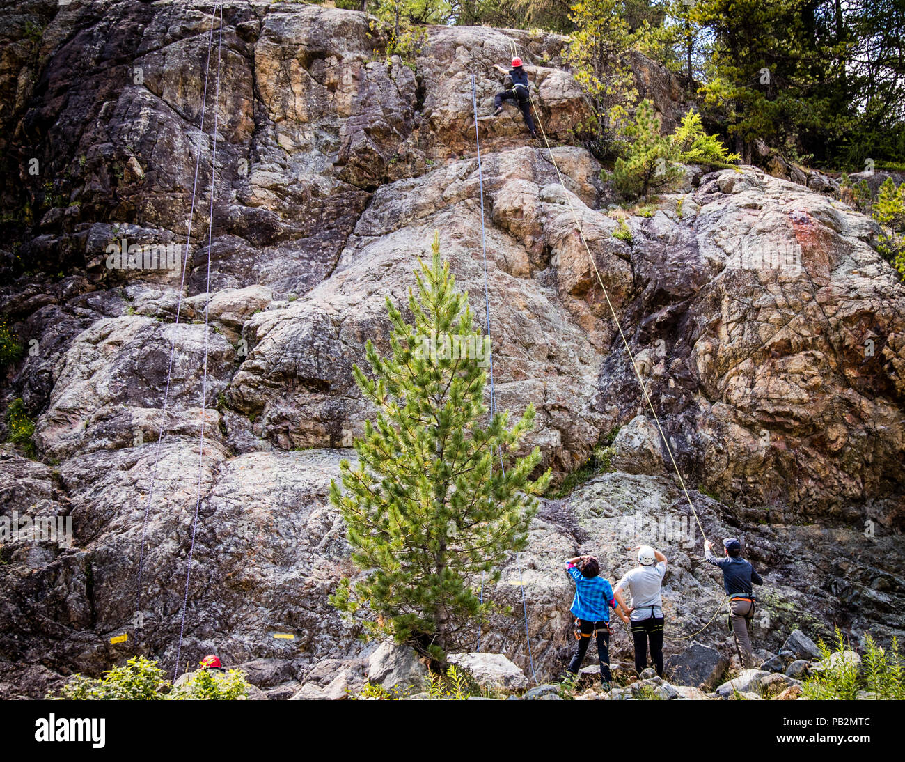 Rock Climbing with rope. Even those who have never conquered such steep rocks, discover unimagined abilities in themselves Stock Photo