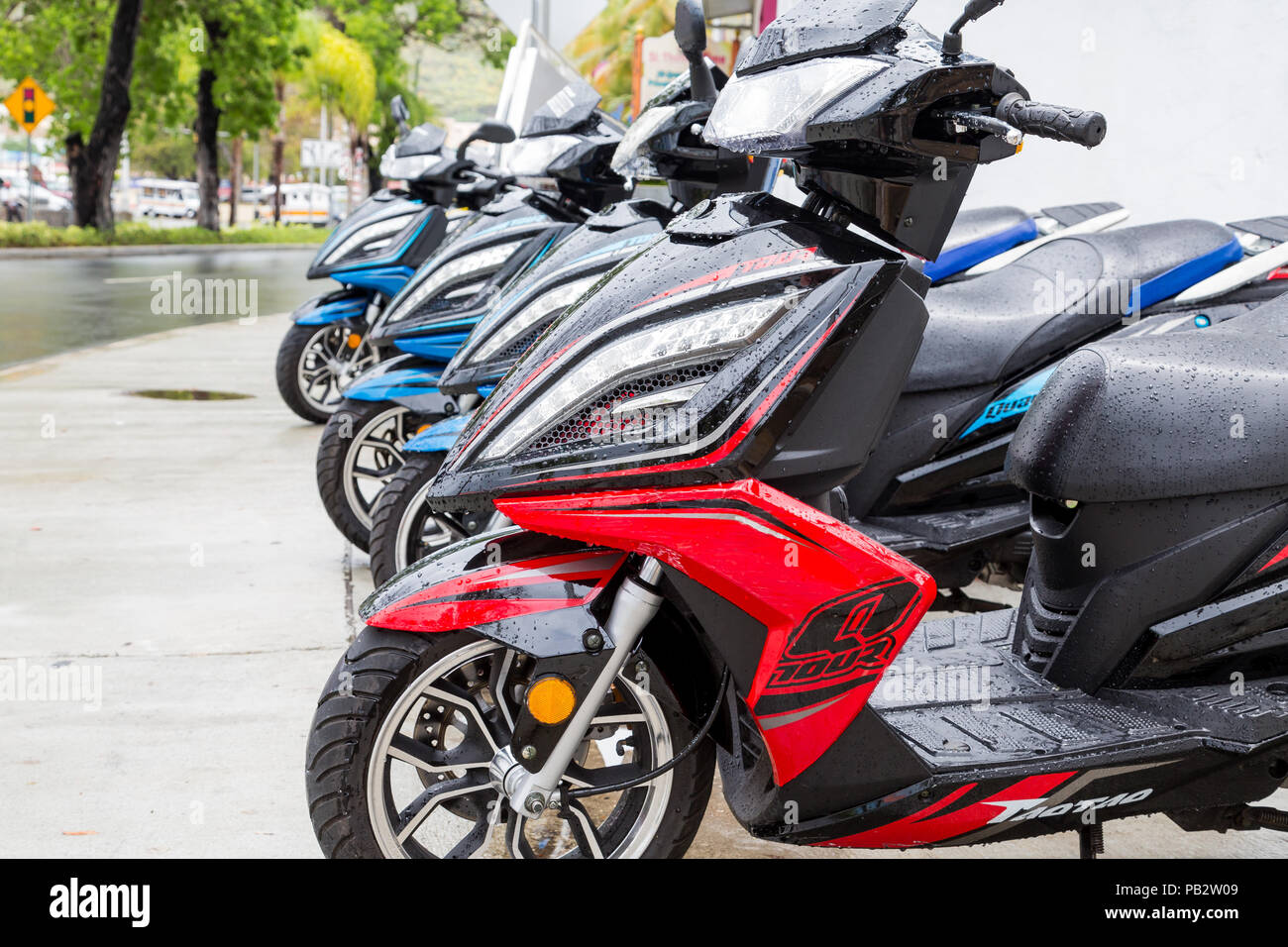 A row of colorful mopeds after a rain in St Thomas Stock Photo