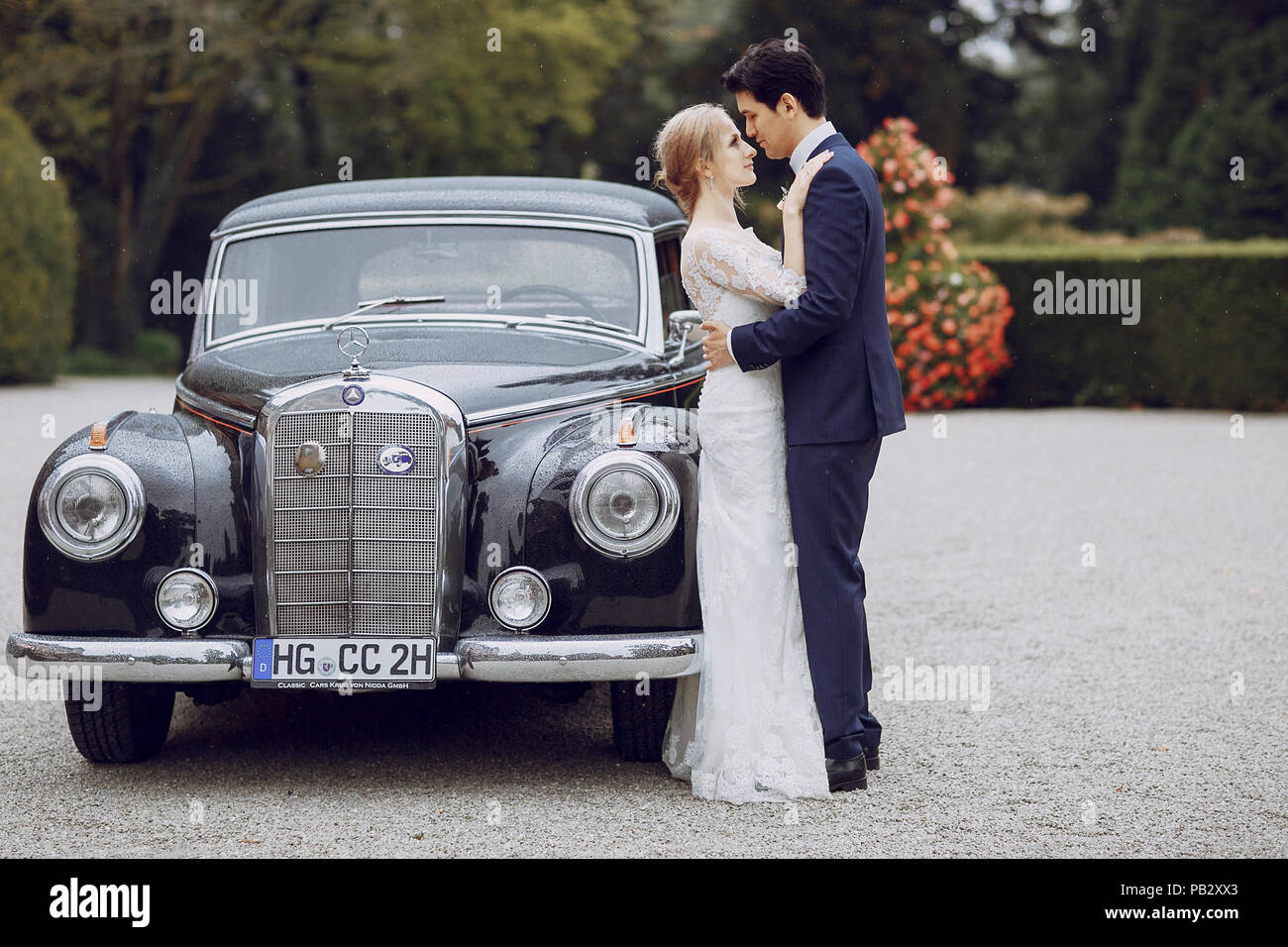 bride and groom standing in the yard near the car Stock Photo - Alamy