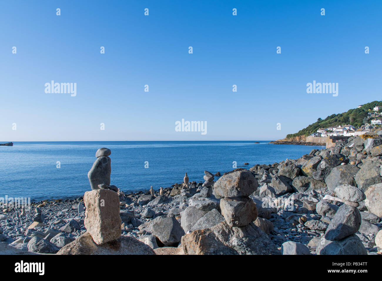 Mousehole, Cornwall, UK. 26th July 2018. UK Weather. Locals awoke to find the rocky beach at Mousehole had been 'fairy stacked' with the stones precariously balanced on top of each other. Credit: Simon Maycock/Alamy Live News Stock Photo