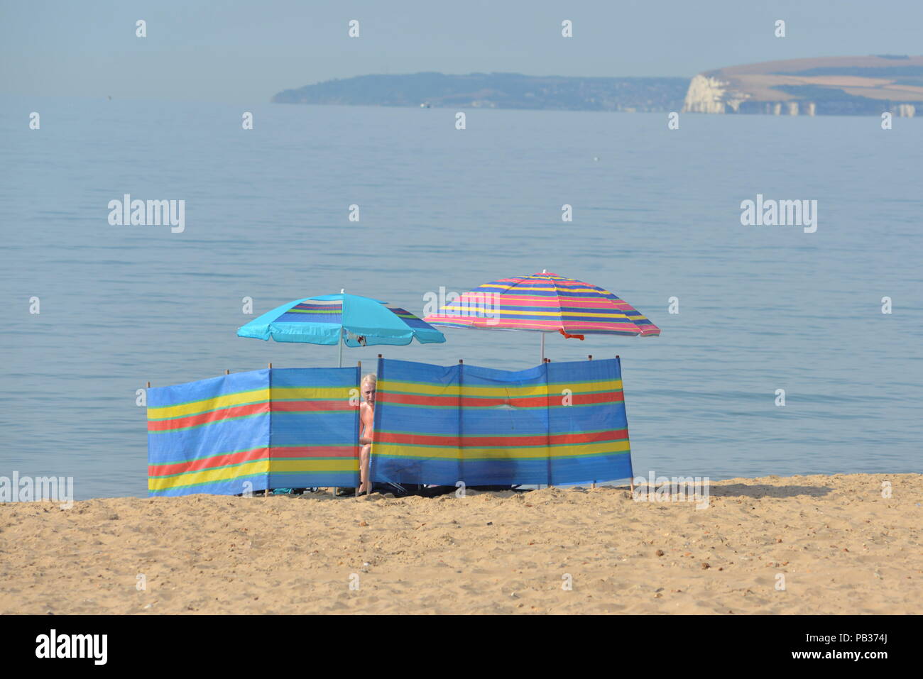 Wind shield and sun umbrellas in hot weather on the beach during a