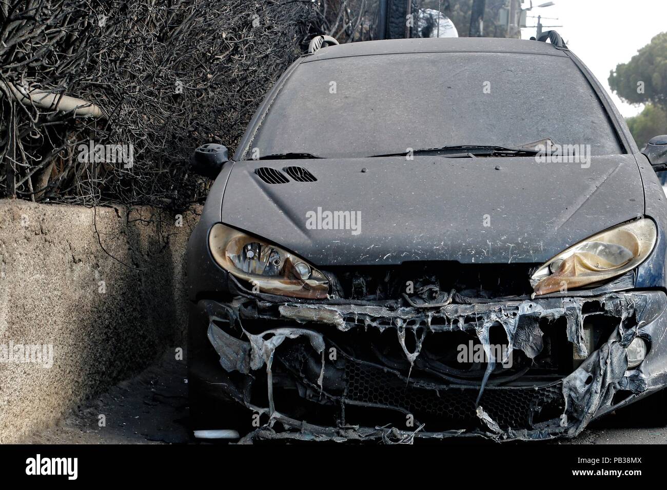 Athens, Greece. 25th July, 2018. A charred vehicle after a wildfire