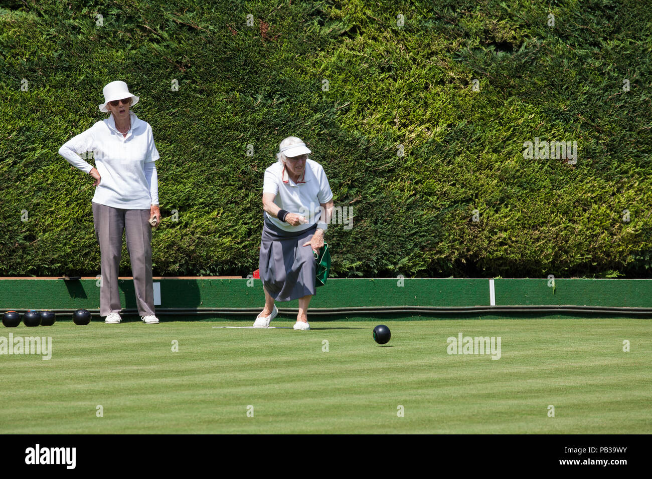 Windsor, UK. 26th July, 2018. Two women enjoy a game of bowls on a still pristine lawn at the Windsor and Eton Bowling Club on a very hot summer's day. Temperatures are expected to reach 36C today in the south-east. Even if imposed, sports facilities such as bowling clubs are often exempt from water restrictions during a drought. Credit: Mark Kerrison/Alamy Live News Stock Photo