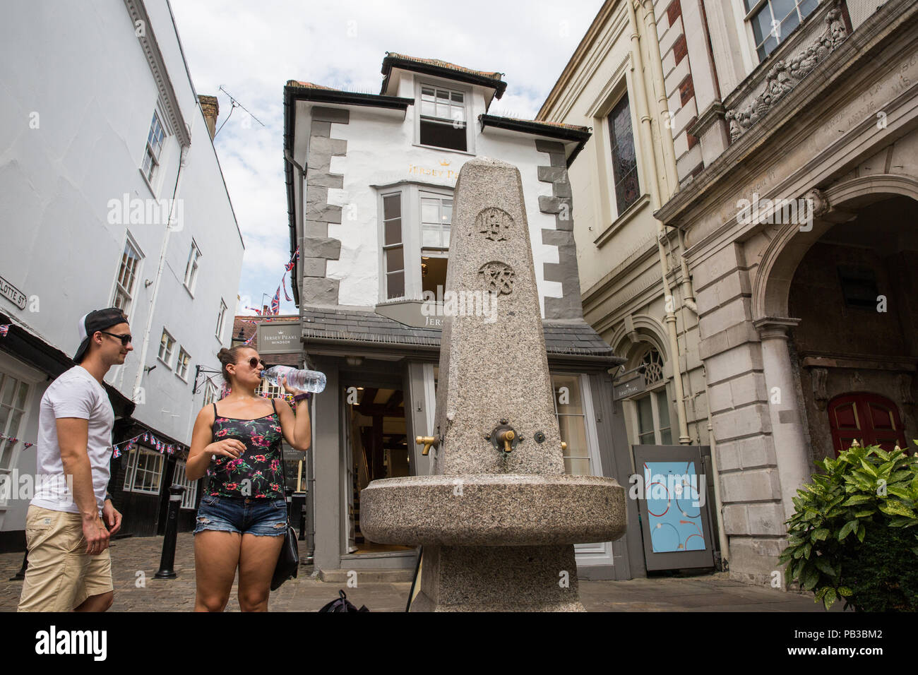 Windsor, UK. 26th July, 2018. UK Weather: Visitors drink and fill up water bottles from a drinking fountain erected outside the Guildhall in 1878 on an unusually hot summer's day. Temperatures have already reached 35C today at nearby Heathrow airport. Credit: Mark Kerrison/Alamy Live News Stock Photo