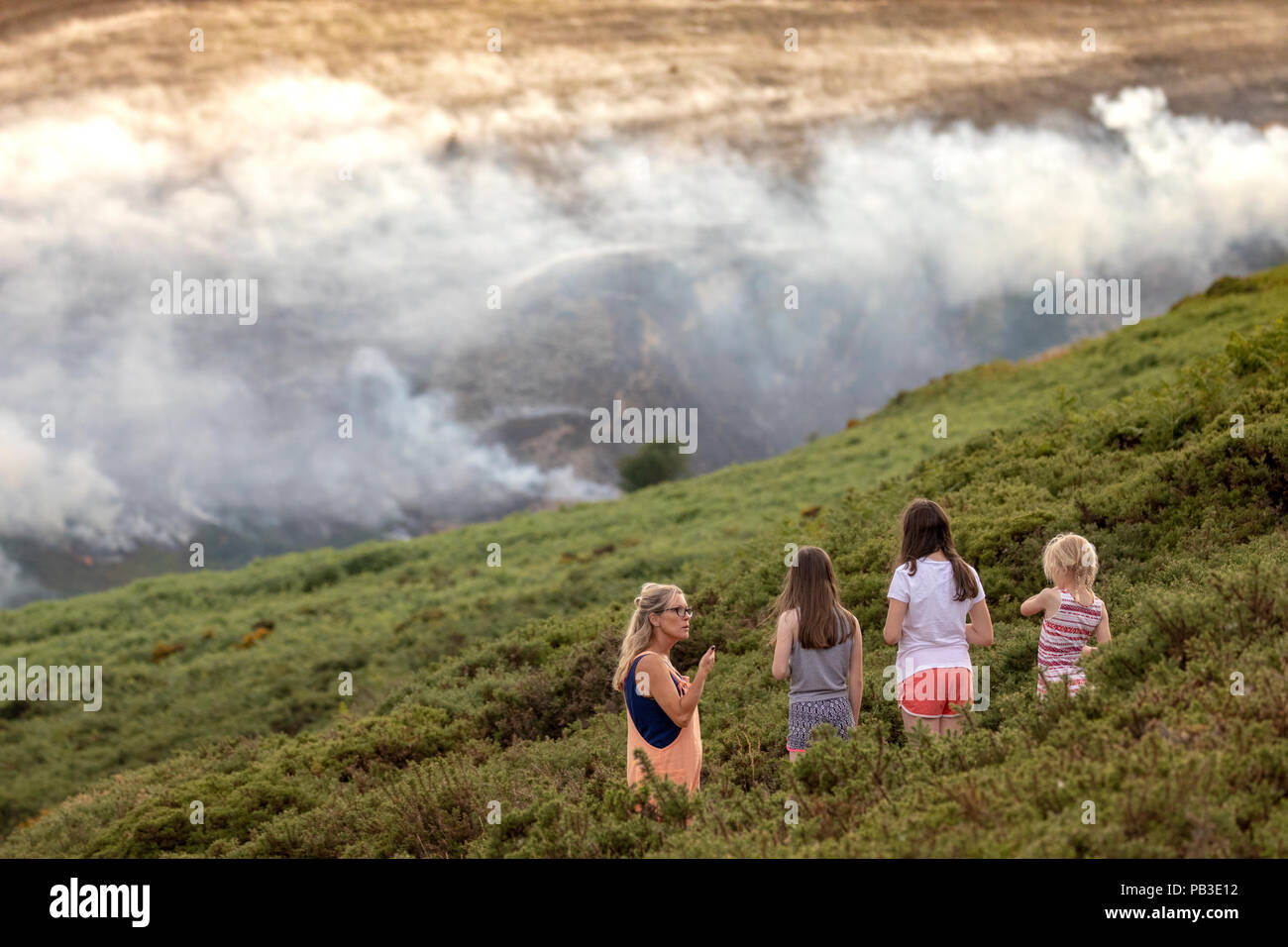 Public spectators watching the moorland fire at Llantysilio Mountain along the Horseshoe Pass, Llangollen as the fire burns over the mountain due to heatwave temperatures in the UK Stock Photo