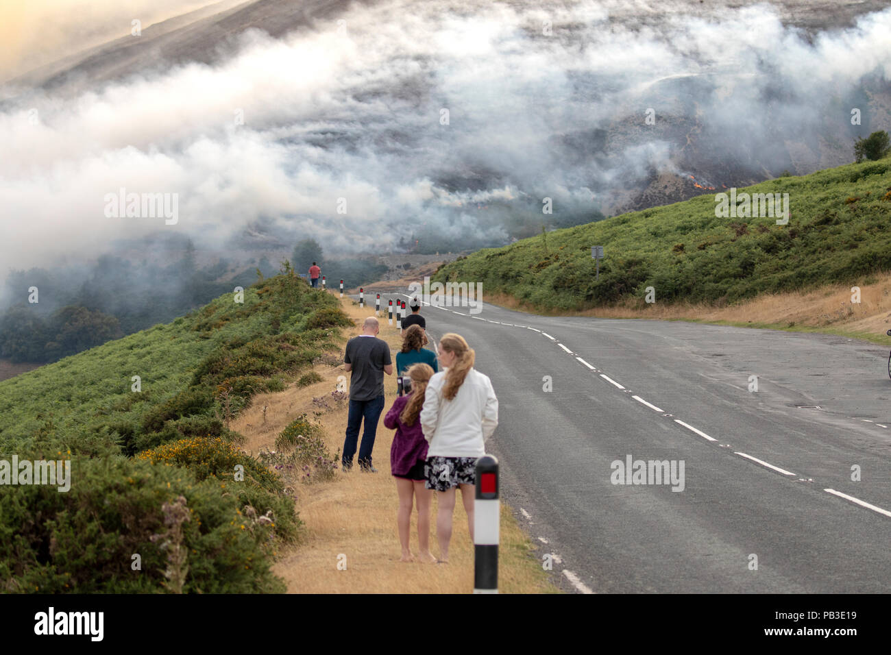 Public spectators watching the moorland fire at Llantysilio Mountain along the Horseshoe Pass, Corwen near Llangollen as the fire burns over the mountain due to heatwave temperatures in the UK Stock Photo