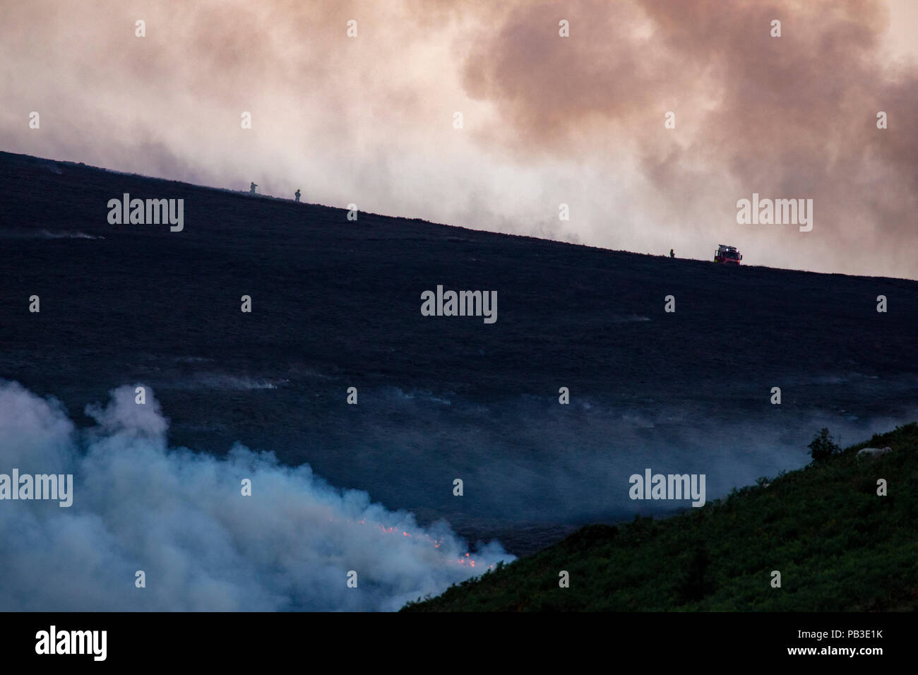 Fire fighters and their appliances tackling the  moorland fire at Llantysilio Mountain along the Horseshoe Pass, Corwen near Llangollen as the fire burns over the mountain due to heatwave temperatures in the UK Stock Photo