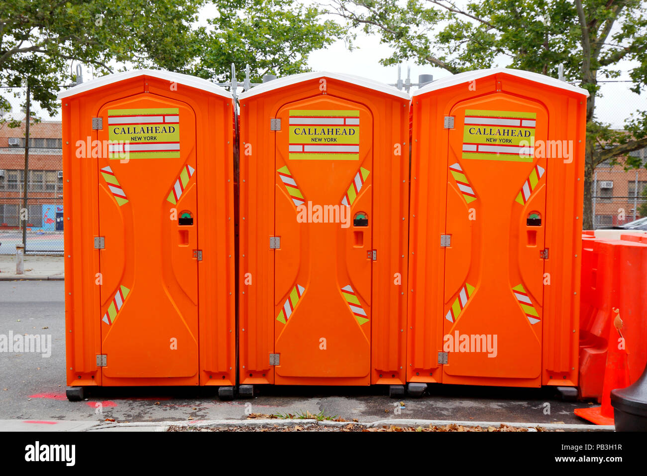 Orange Callahead Portable Toilets, or porta potties, on a sidewalk. Stock Photo