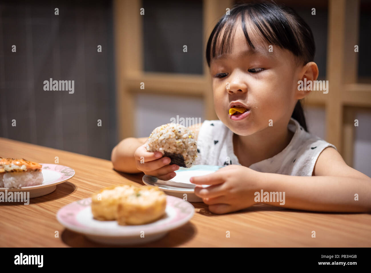Asian little Chinese girl eating rice balls at a Japanese restaurant Stock ...