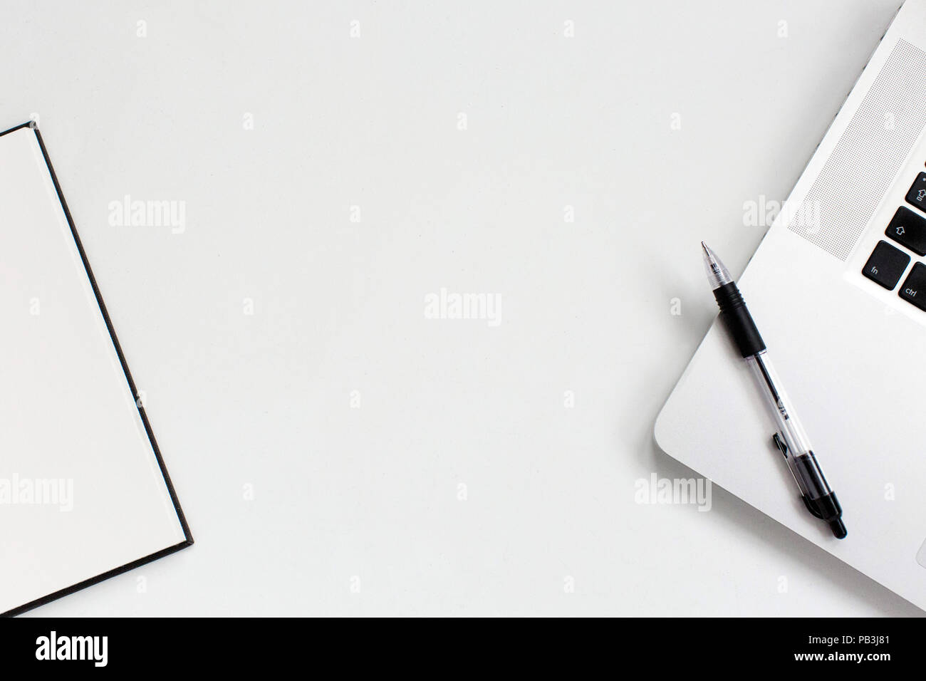 Flat lay of office desk top with empty notebook and laptop on white Stock Photo