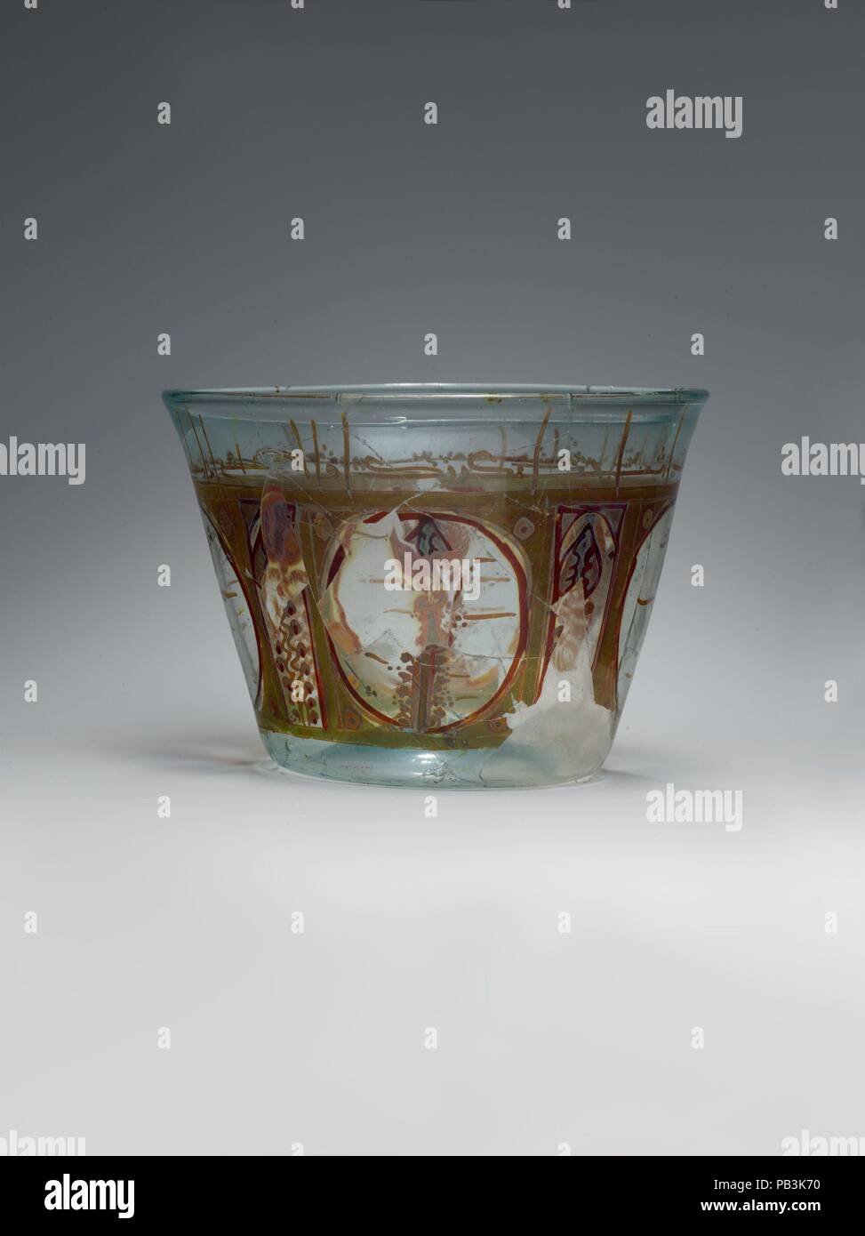 Glass Bowl. Dimensions: H. 4 3/16 in. (10.7 cm)  Max. Diam. 6 in. (15.3 cm). Date: late 10th-early 11th century.  The shape, size, and decoration of this bowl demonstrate an affinity between luster-painted glass and ceramic lusterware. The division of the vessel walls into panels and the stylized palmette-tree motifs frequently appear on luster-painted bowls made in Fatimid Egypt. The Arabic inscription around the rim, in angular kufic script, has not yet been deciphered. Museum: Metropolitan Museum of Art, New York, USA. Stock Photo