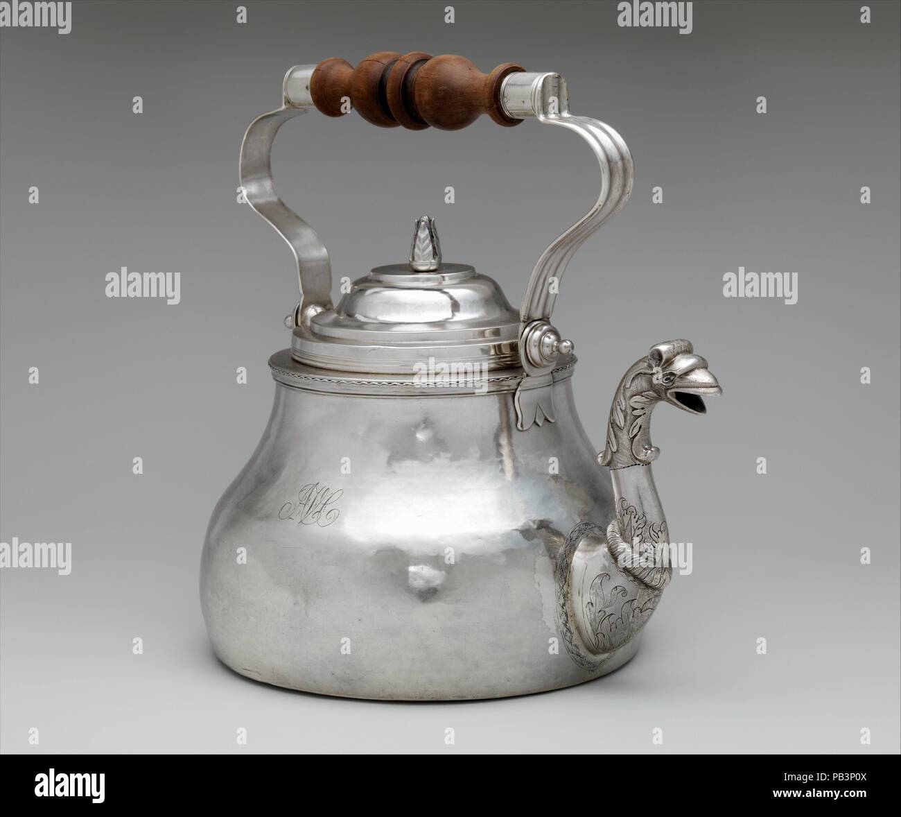 Teakettle. Culture: American. Dimensions: Overall: 10 1/8 x 10 5/8 in. (25.7 x 27 cm); 47 oz. 13 dwt. (1481.7 g)  Base: Diam. 7 3/8 in. (18.7 cm)  Body: H. 7 7/16 in. (18.9 cm). Maker: Cornelius Kierstede (1674-ca. 1757). Date: 1710-20.  As in England and the Netherlands, tea drinking became increasingly popular in colonial America, creating a demand for specialized tea equipment such as teapots, sugar bowls, and creampots. This bold, pear-shaped teakettle with bail handle is an extremely rare form in American silver. Its decorative bird's-head spout, distinctively Dutch in inspiration, enlive Stock Photo