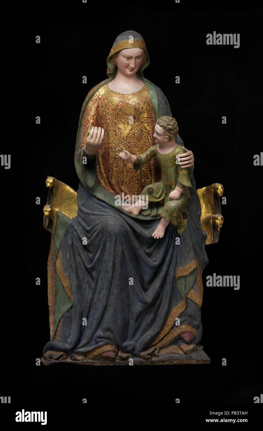 Enthroned Virgin and Child. Culture: Italian. Dimensions: Virgin and Child only: 64 1/4 × 35 × 14 3/4 in., 54 lb. (163.2 × 88.9 × 37.5 cm, 24.5 kg). Date: mid-14th century.  The sculpture is created by pressing linen reinforced with glue into shallow molds and mounting the figure on a wood backing and adding paint and gilding. This work seems to be a unique surviving example of this technique. The Virgin is seated upon a throne displaying lion heads, a reference to the Throne of Solomon.   Significantly, a number of votive offerings are incorporated into the interior of the figure: a pearl ros Stock Photo