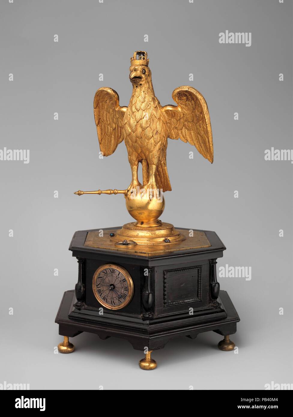 Automaton clock in the form of an eagle. Culture: German, Augsburg. Dimensions: Overall: 13 1/4 × 9 1/8 × 7 5/8 in. (33.7 × 23.2 × 19.4 cm). Date: ca. 1630.  European clocks were often, and from the outset, associated with the creation of automata--moving, mechanized figures or contrivances. Seventeenth-century Augsburg clockmakers specialized in small domestic examples. Here, when the clock strikes the hour, the scepter moves, and on the quarter hours the eagle opens and shuts its beak and rolls its eyes. The eagle emblem of the Habsburgs had special meaning for inhabitants of Augsburg, a fre Stock Photo