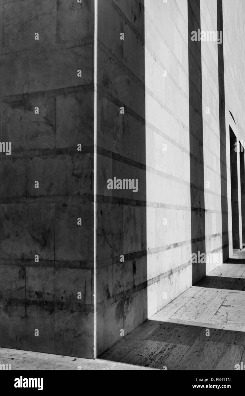 Shadows of a columns row cast on a building facade ,black and white photo ,geometic shape ,vertical composition ,wide angle lens , Stock Photo