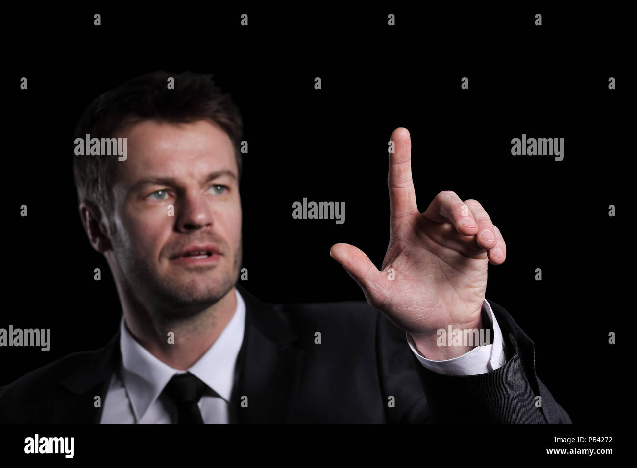 Business man pushing the imaginary  button. Isoladed on black. Stock Photo