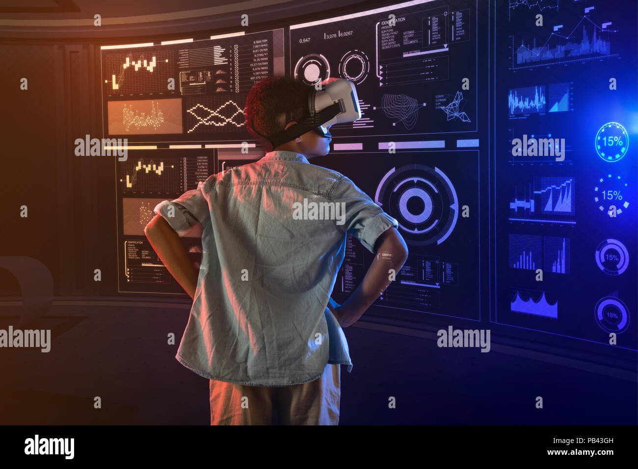 Curious boy having his hands on the hips and wearing virtual reality ...