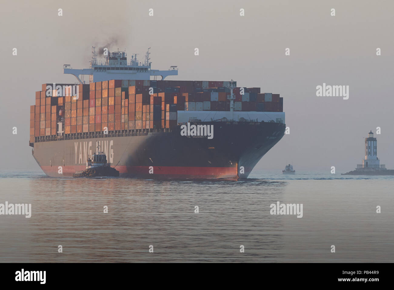 The Giant YANG MING Container Ship, YM UNANIMITY, Enters The Los Angeles Main Channel, The Angels Gate Harbor Light To The Right. California, USA. Stock Photo