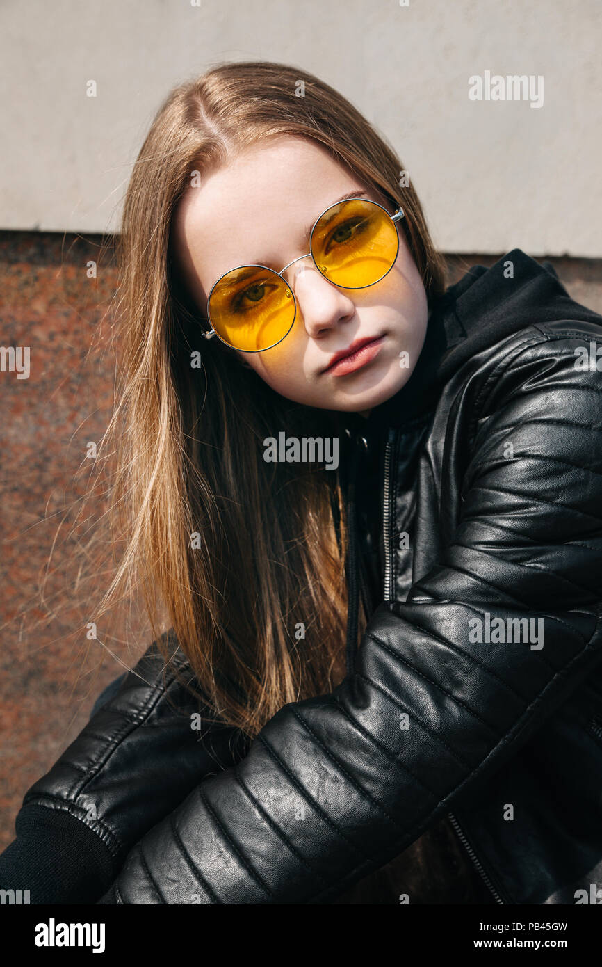 beautiful fashionable teenager girl with long hair in yellow sunglasses in  city, Street fashion kid Stock Photo - Alamy
