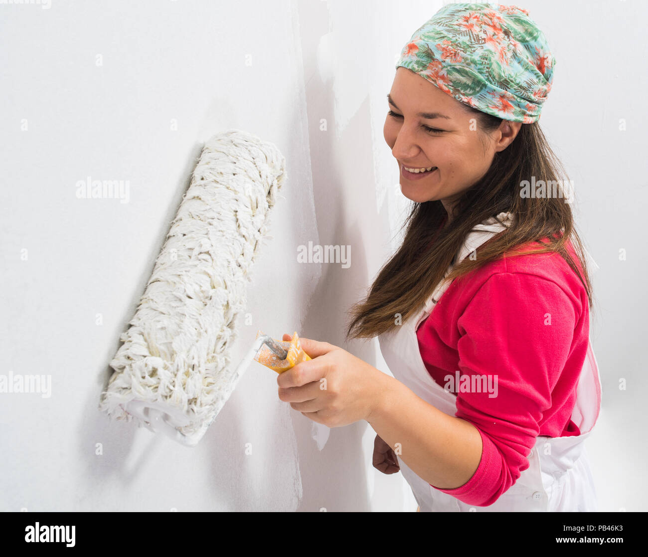 Happy pretty young woman painting a wall Stock Photo - Alamy