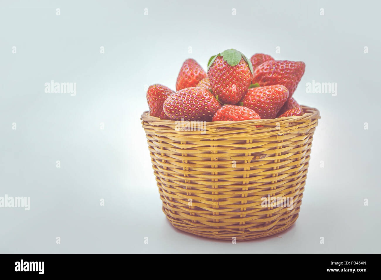 vintage effect style of Strawberries in basket on white background ...
