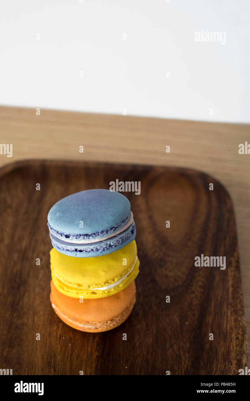French Macaroons / Macron Trio - Tasty Pasty Options on a Dark Wooden Plate Stock Photo