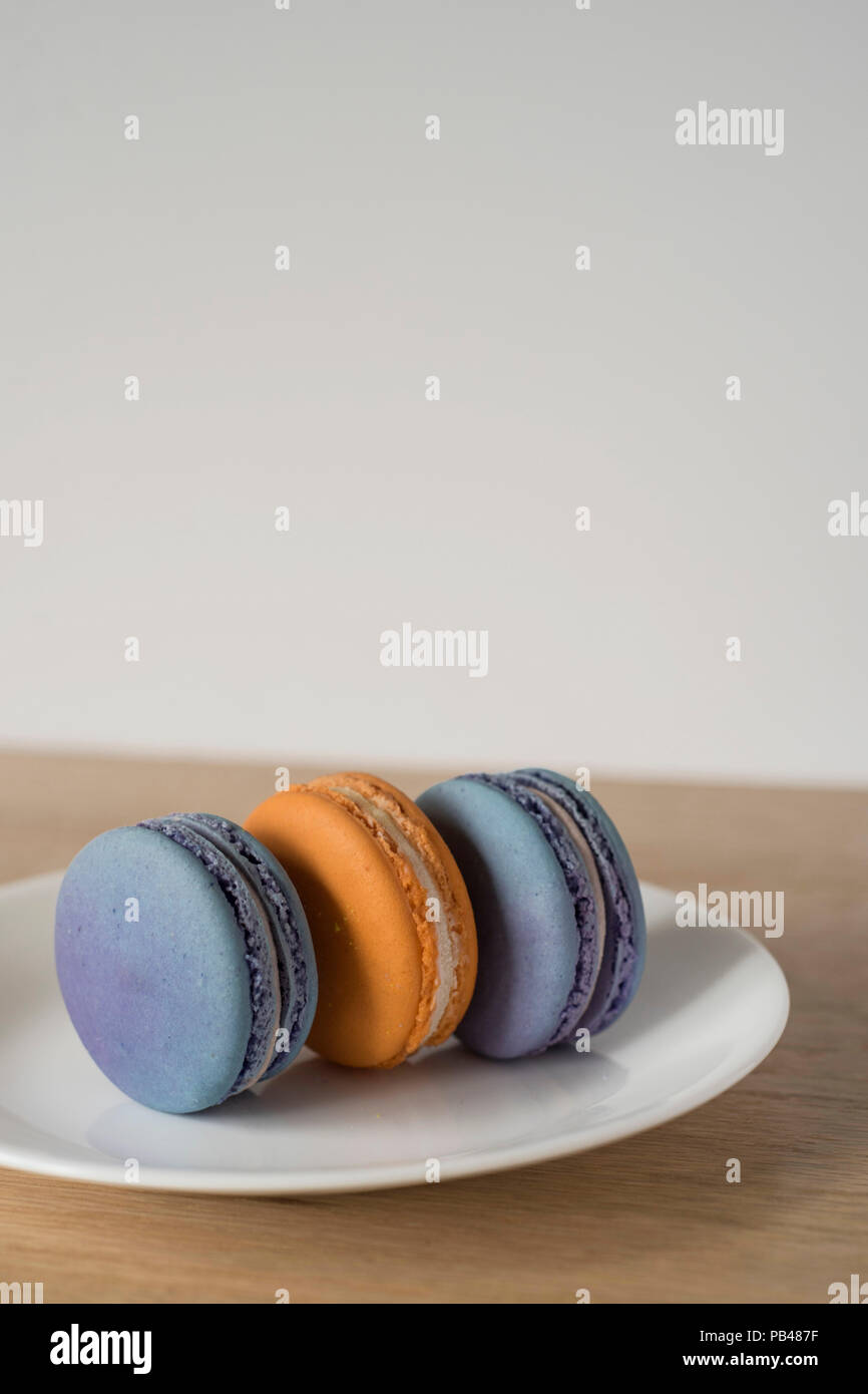 Trio of Two-Color Macarons Standing on a Plate for Dessert Stock Photo