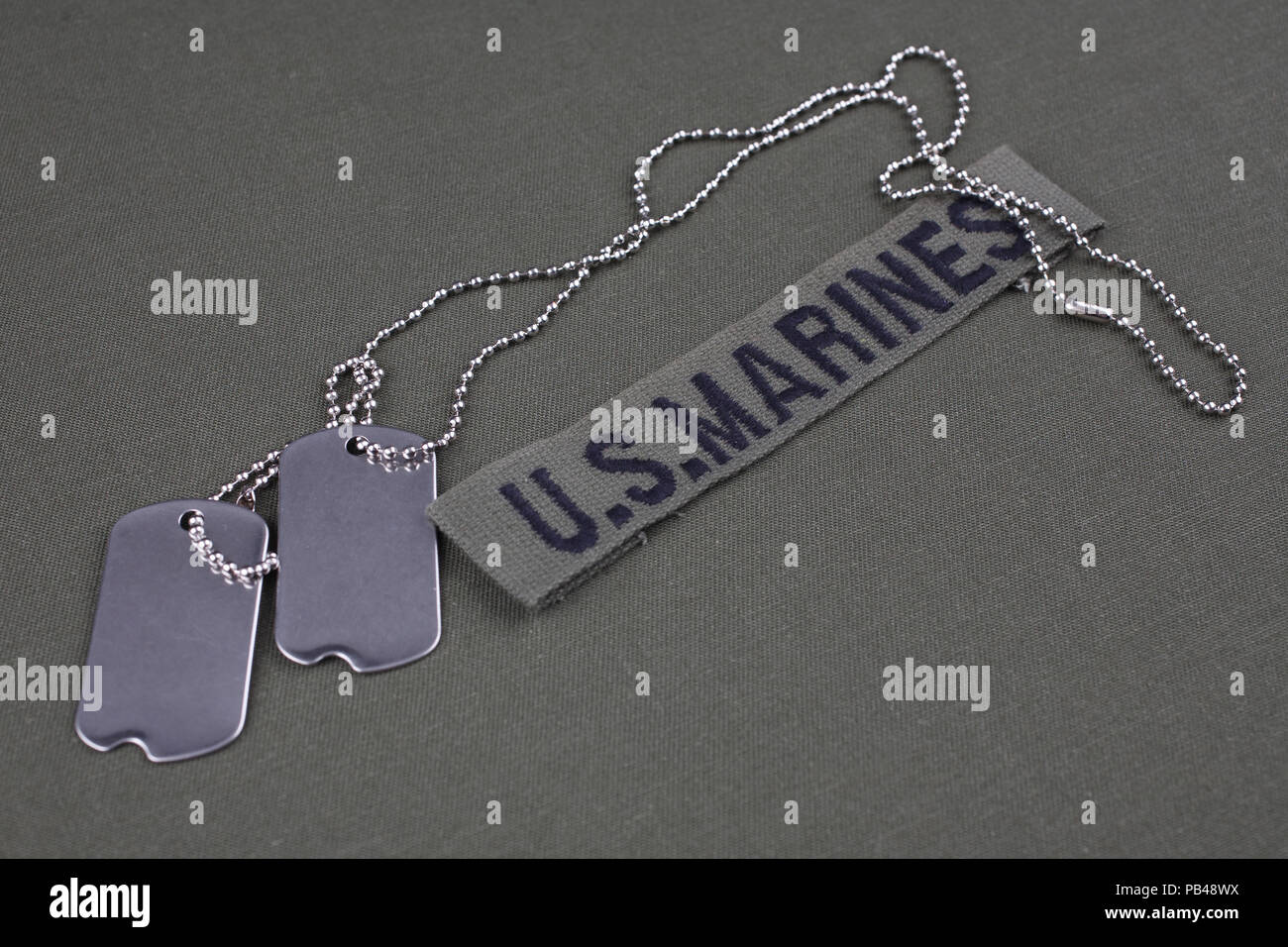 U.S. MARINES Tape with dog tags on olive green uniform background Stock