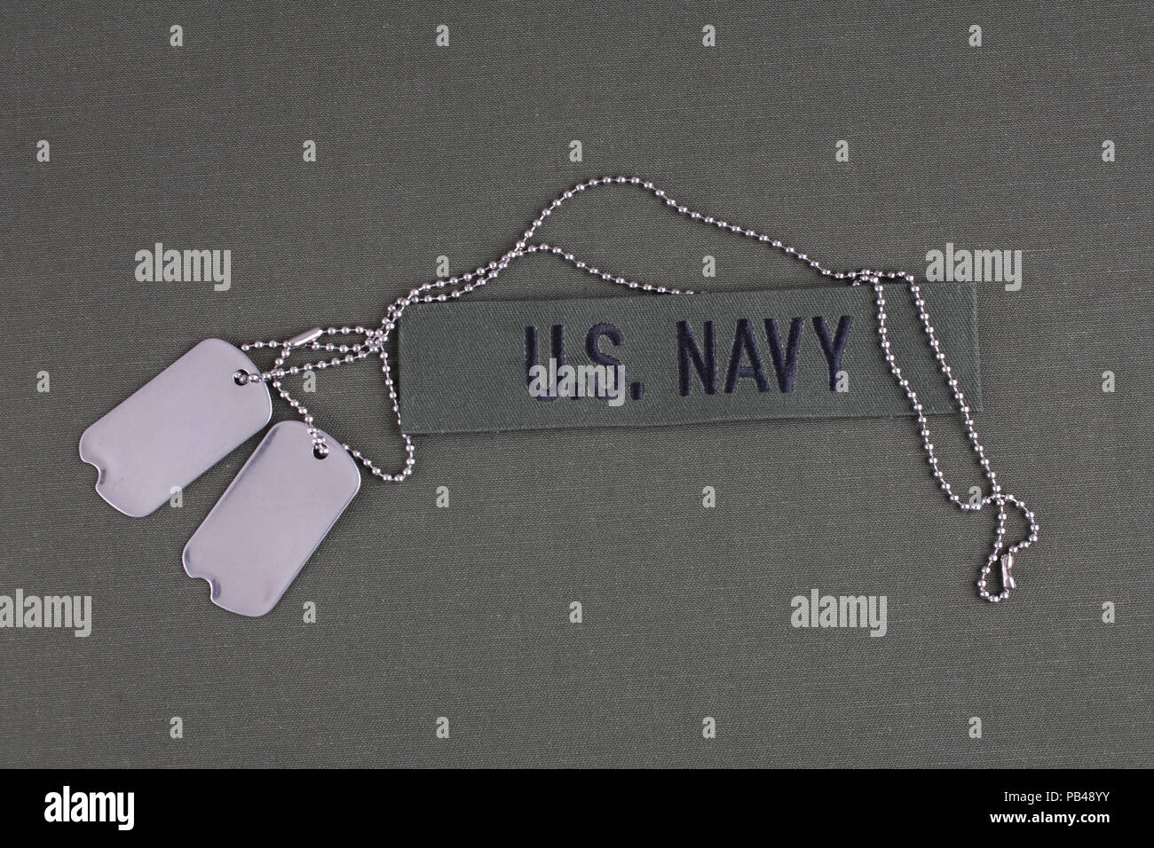 U.S. Navy Branch Tape with dog tags on olive green uniform background