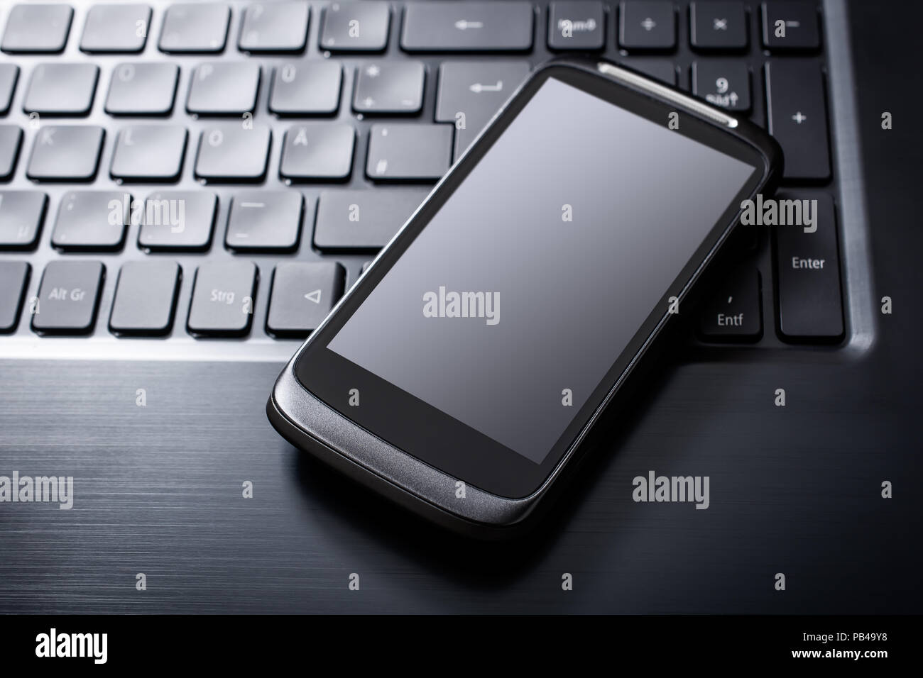Black Smartphone With Reflection Lying On The Keyboard Of A Black ...