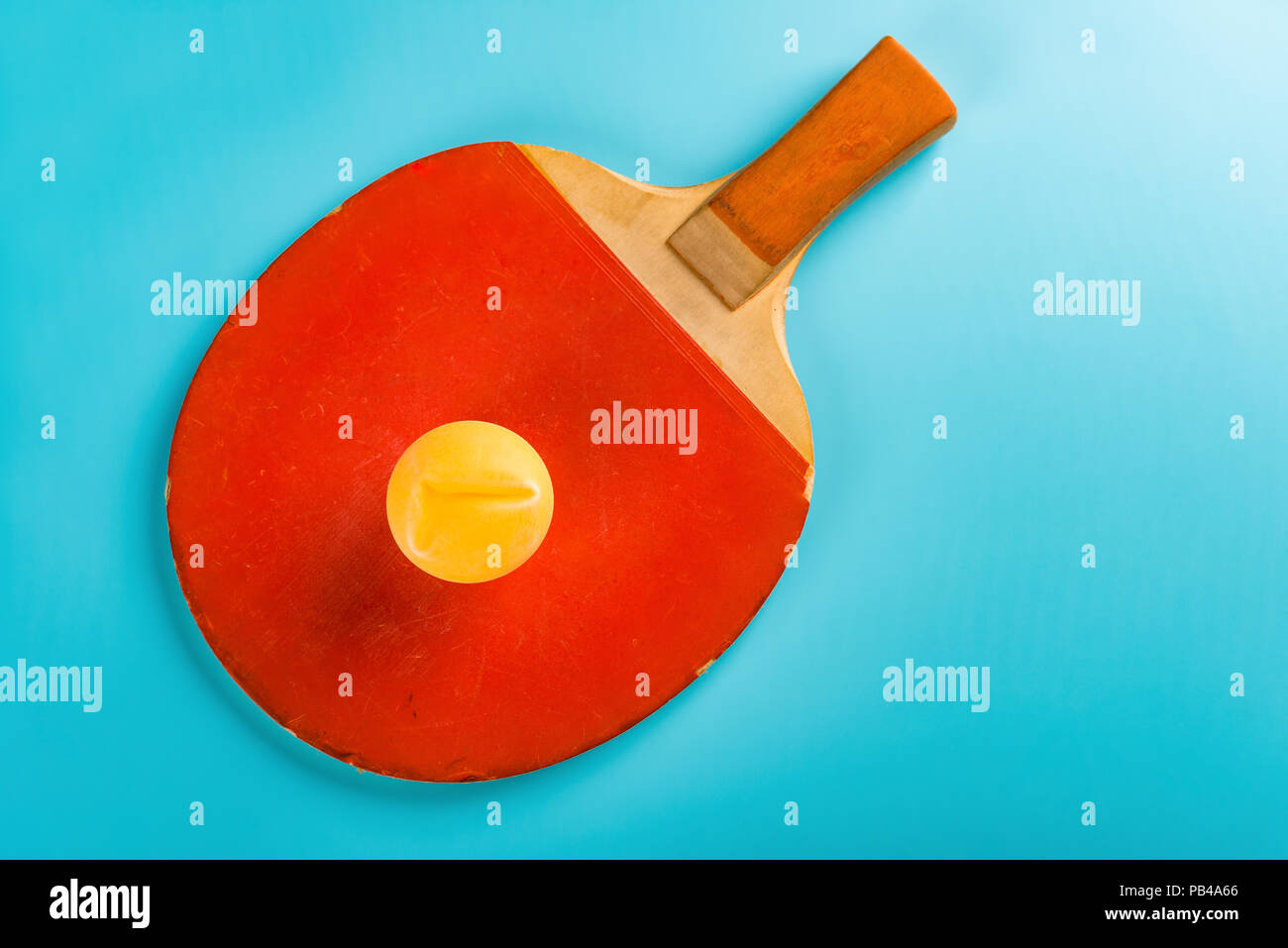pingpong racket and a ball on blue background Stock Photo