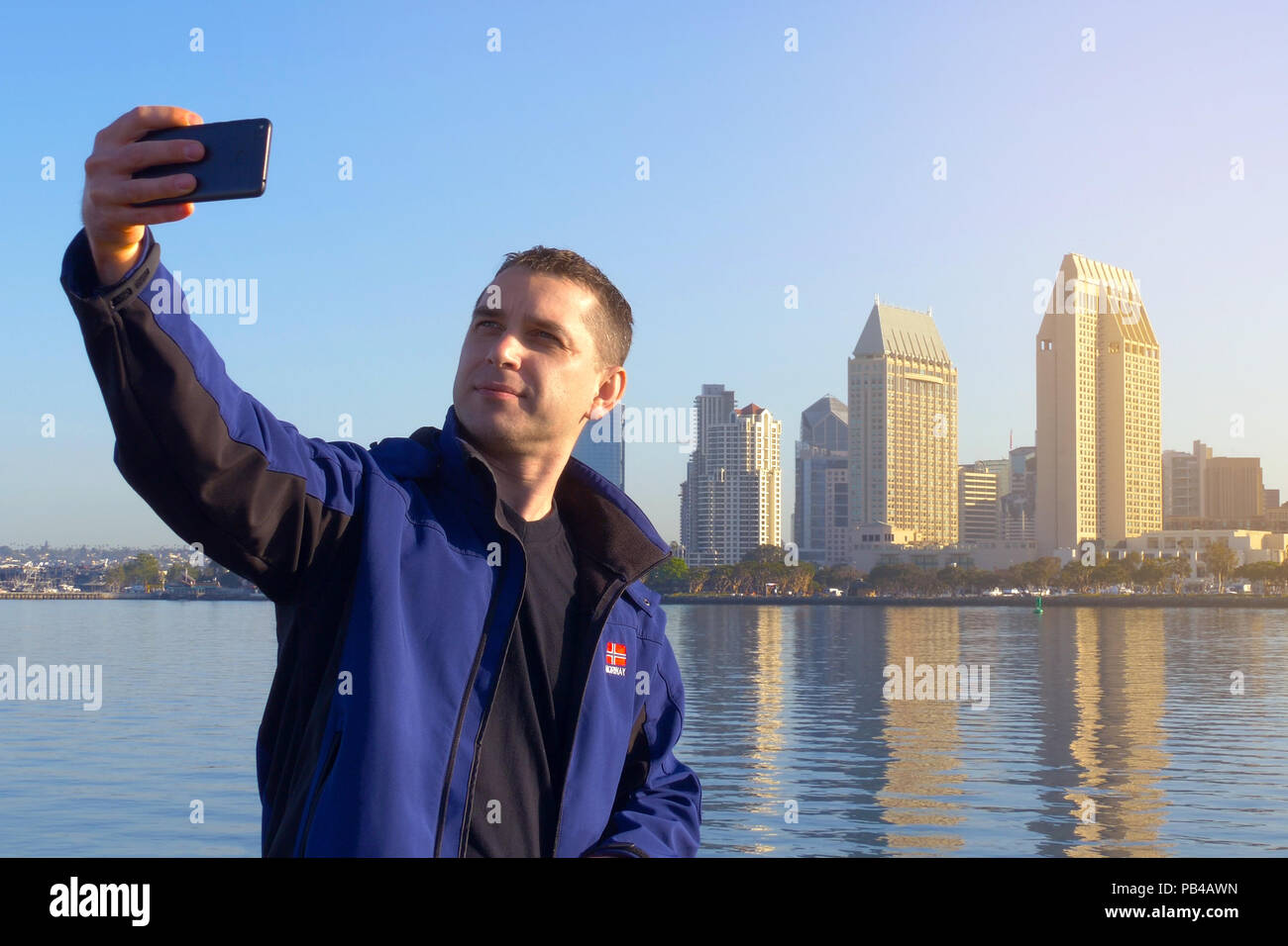 San Diego City selfie photo by young adult male. Smiling caucasian man portrait. Man poses on camera and does selfie early morning in San Diego. Mobil Stock Photo