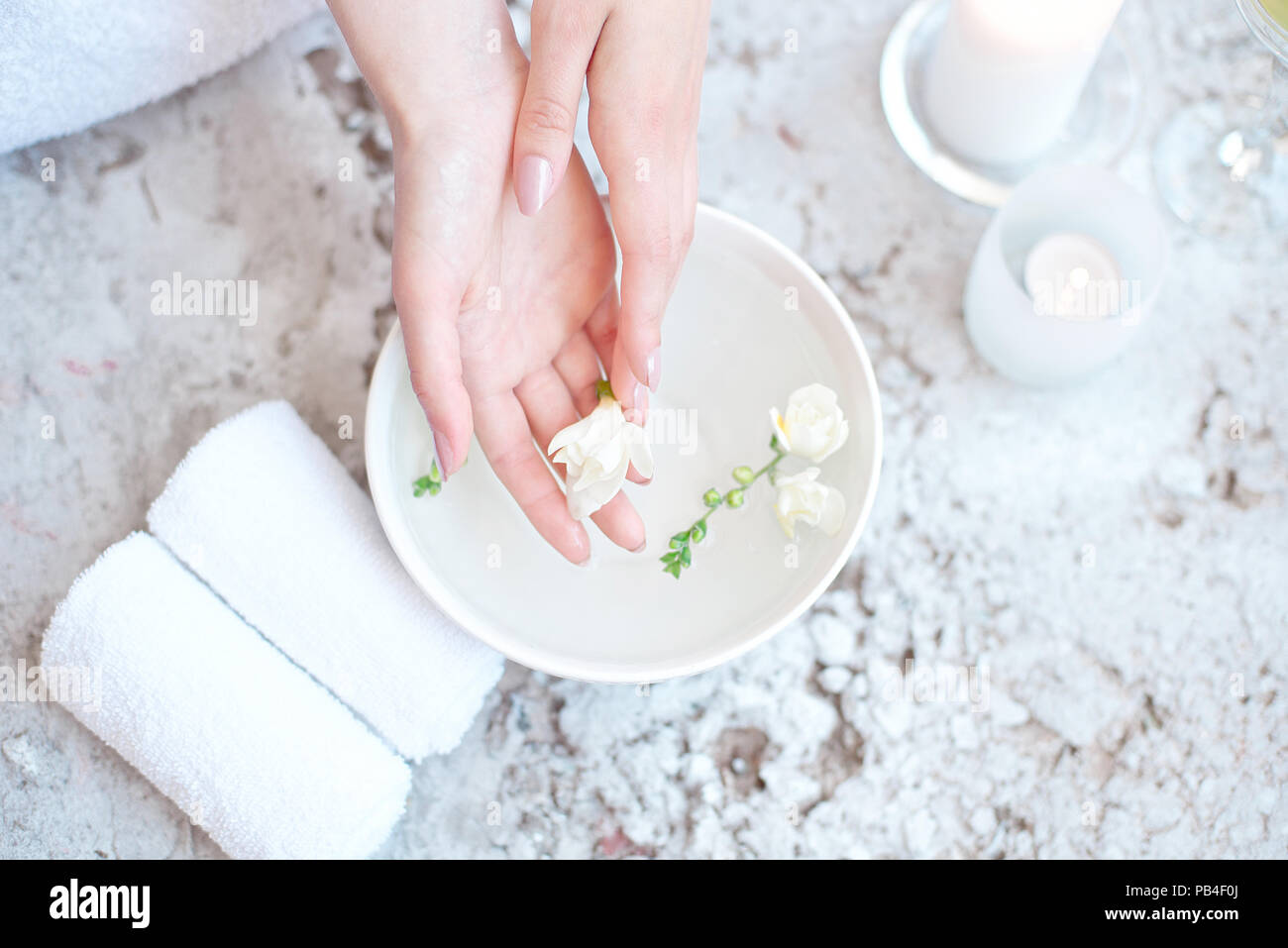 Woman In Beauty Salon Holding Hands In Aroma Bath Before Spa Procedure