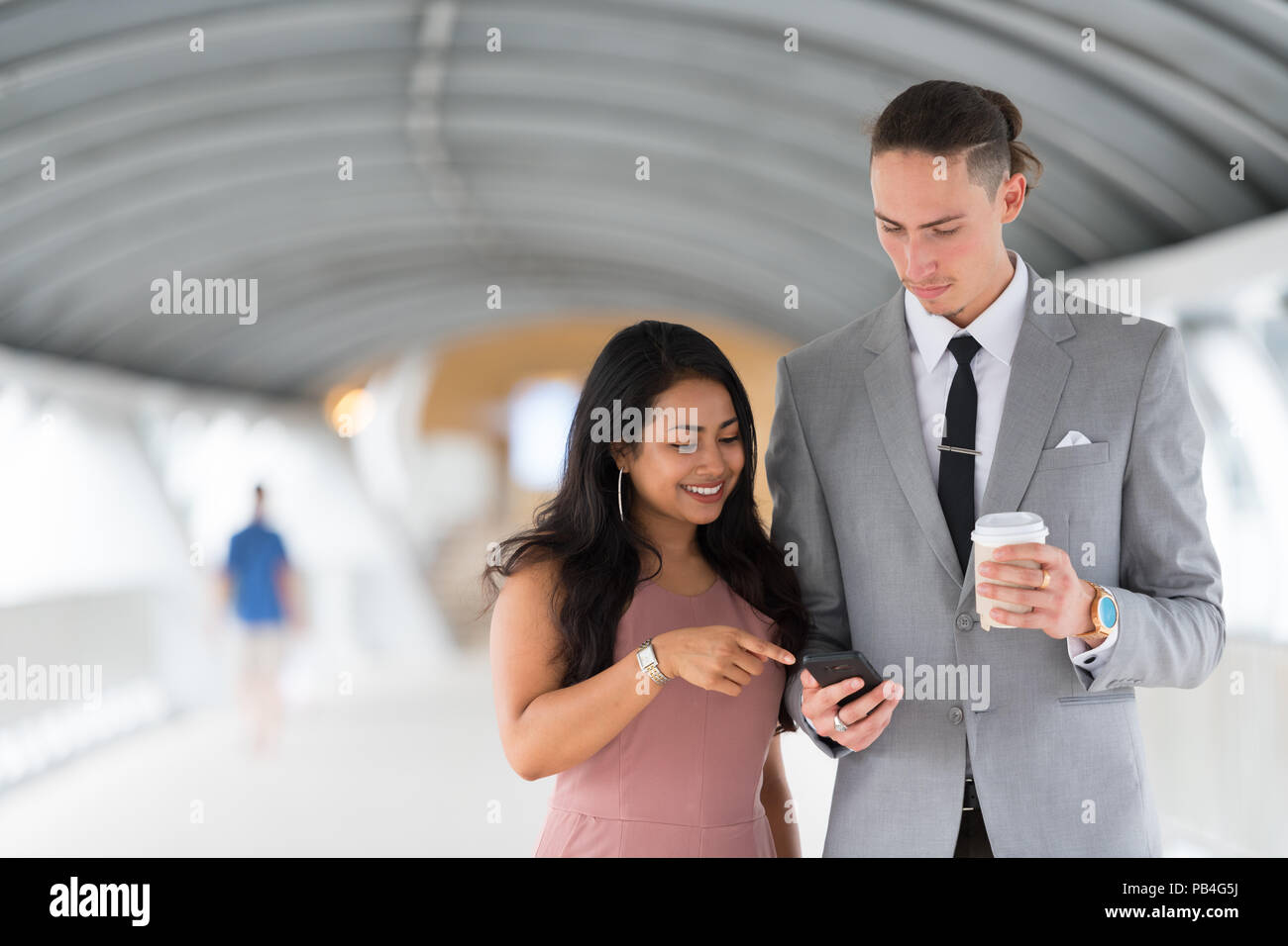 Business couple using mobile phone outdoors Stock Photo