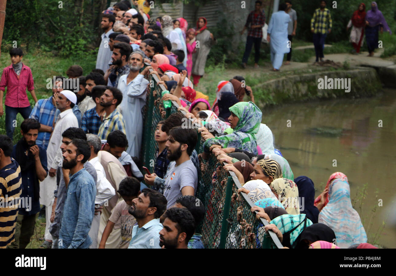 India. 25th July, 2018. Kashmiri villagers looking towards the funeral of Bilal Ahmad, at Khudwani, south of Srinagar, Indian controlled Kashmir, Wednesday, July 25, 2018. Two militants affiliated with Lashkar-e-Toiba (LeT) were killed in an encounter that raged between forces and them in Lal Chowk area of South Kashmir's Anantnag district, police said. The town has witnessed encounter after almost 12 years. Credit: Umer Asif/Pacific Press/Alamy Live News Stock Photo