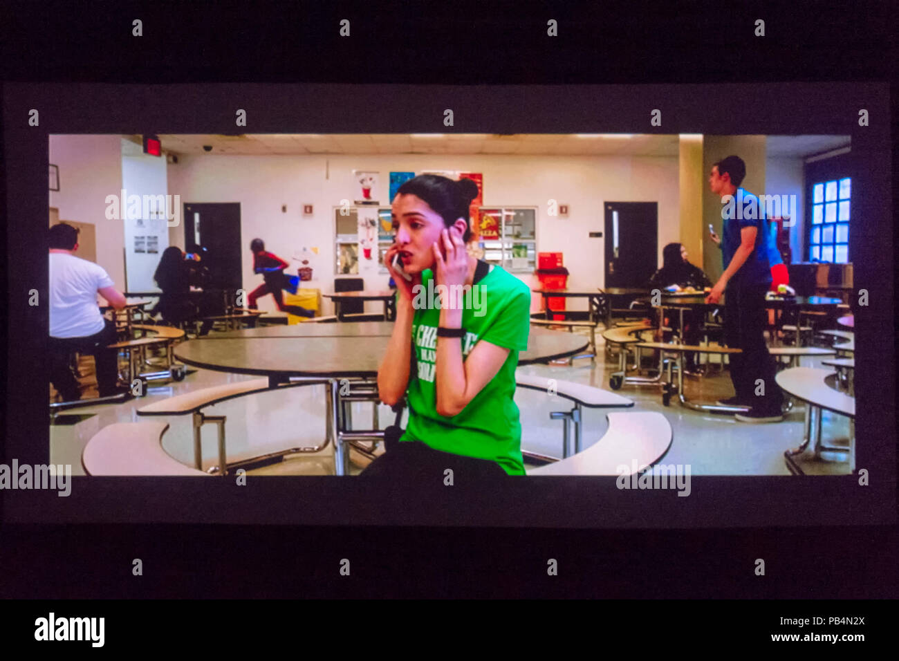 Bellmore, New York, USA. July 18, 2018. In short film The Adventures of Penny Patterson, the title character, played by actor AJNA JAI, calls Steve, her boyfriend and lab partner, who isn't helping with their science fair project. Penny didn't notice Steve was superhero behind her in high school cafeteria. The comedy, sci-fi, woman directed film was nominated for Best Student Film at LIIFE 2018, the Long Island International Film Expo. Stock Photo