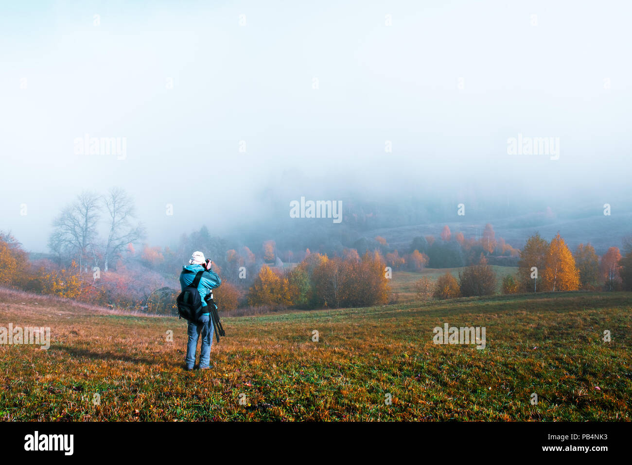 Photographer taking photo of autumn landscape Stock Photo